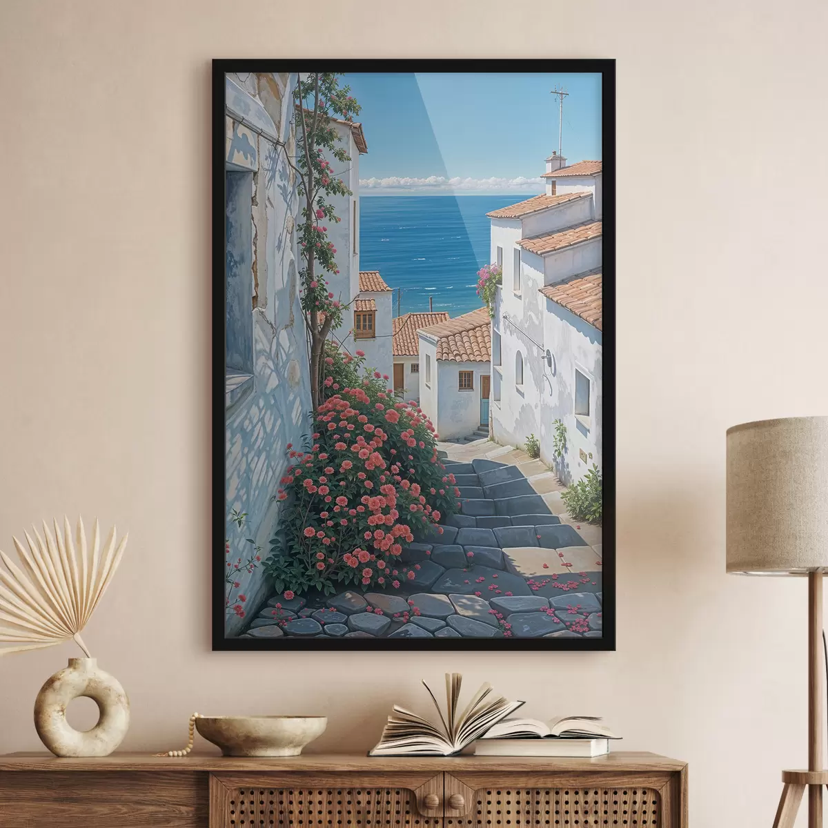 Plakāts Šaura iela piekrastes pilsētā ar baltām ēkām, sarkanu dakstiņu jumtiem un koši rozā ziediem f39532